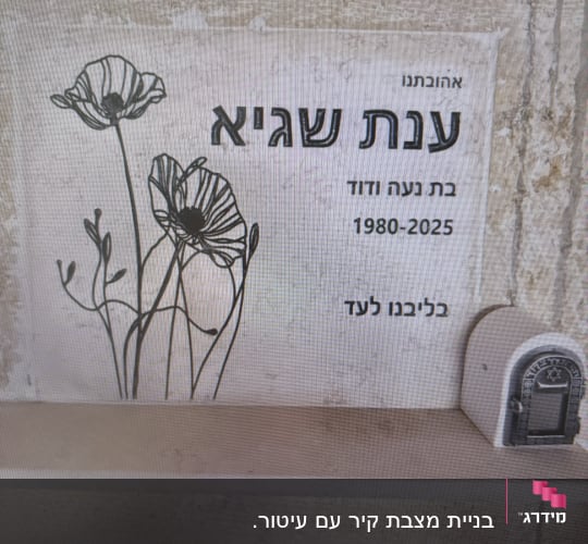 מצבה עם פרחים ושם בעברית